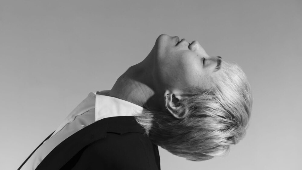 The male model is closing his eyes and looking up
